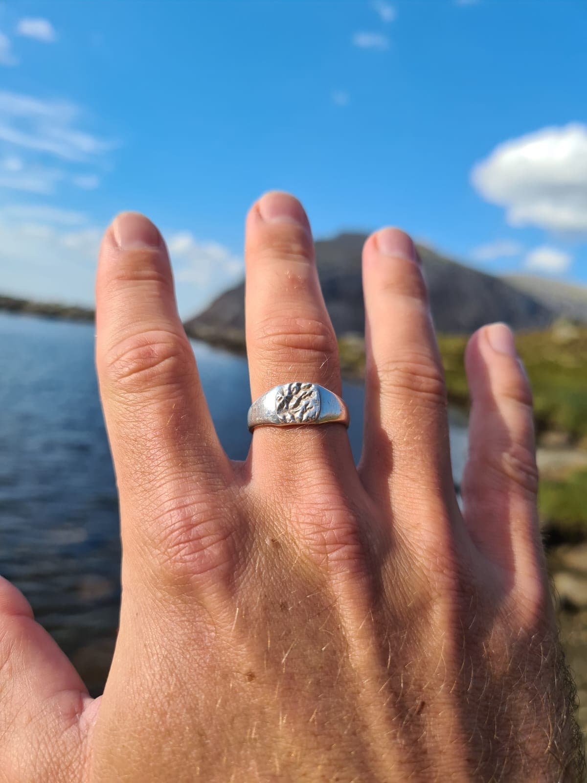 Modern custom map jewellery ring photographed on neutral backdrop